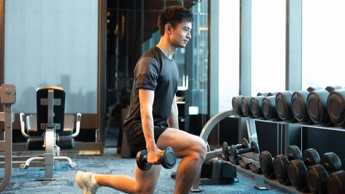 Mert Albayrak spor salonunda dambıl ile lunge yapıyor